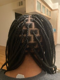 the back of a woman with braids in her hair