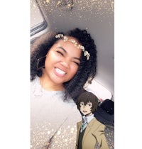 a woman in a car smiling with an anime character